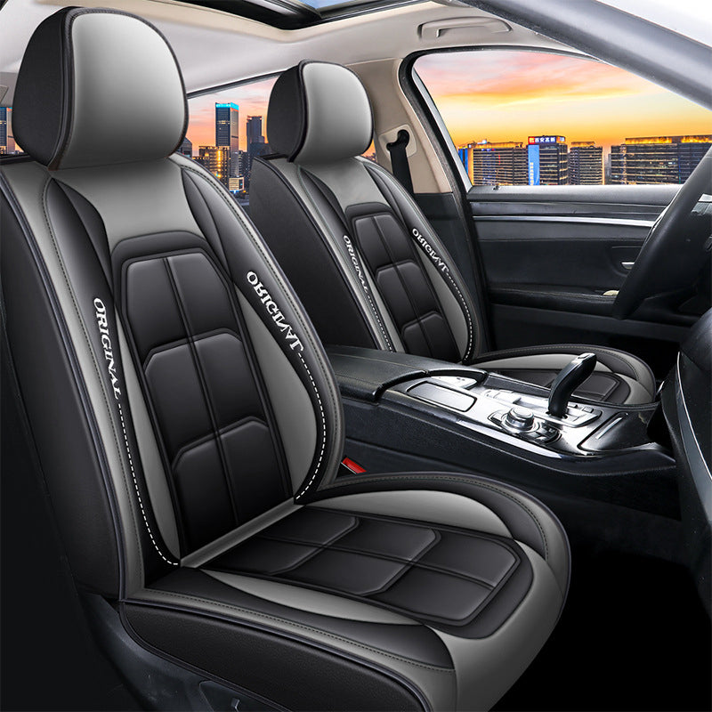 Pair of black front seat covers with gray headrests and gray side panels in a car.