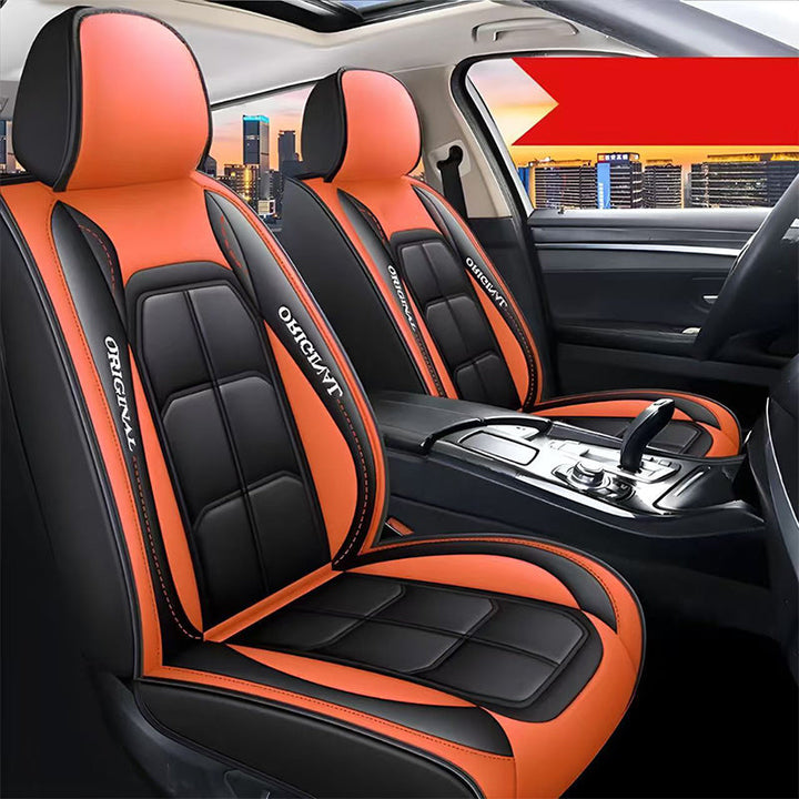 Pair of black front seat covers with orange headrests and orange side panels in a car.