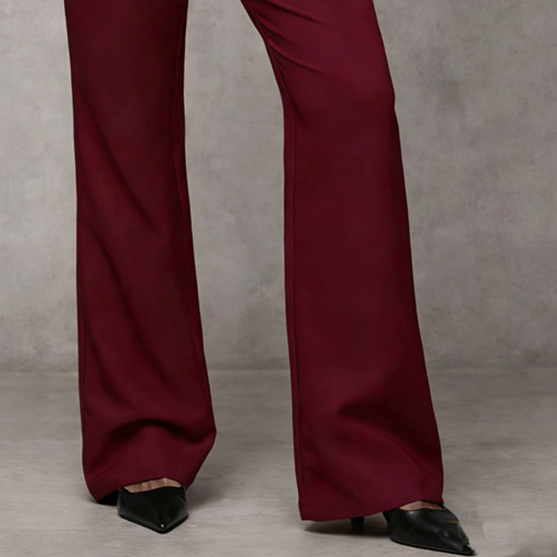 Burgundy wide-leg pant hems falling over black pointed heels, showing the lower leg.