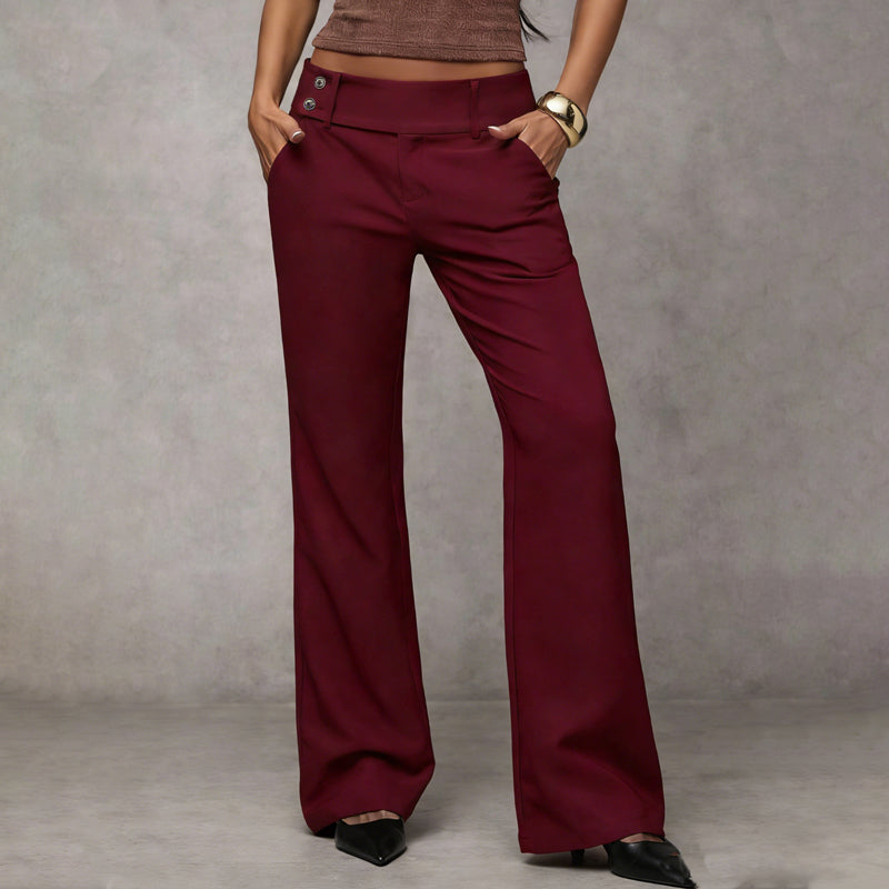 Burgundy wide-leg pants with hands in pockets, styled with a brown top, gold cuff and black heels, front view.