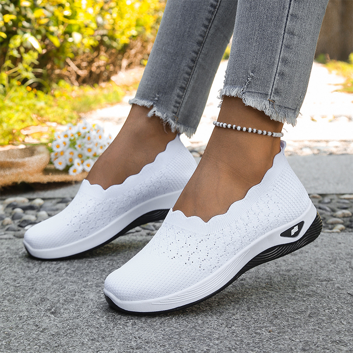 Purple knit slip-on sneakers with a scalloped collar and white sole.