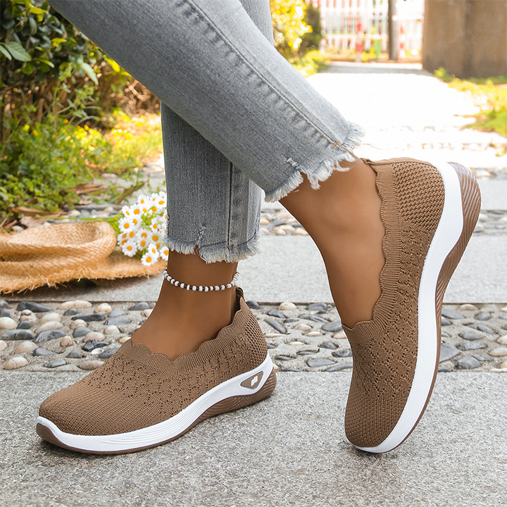 Brown knit slip-on sneakers with a scalloped collar and white midsole.