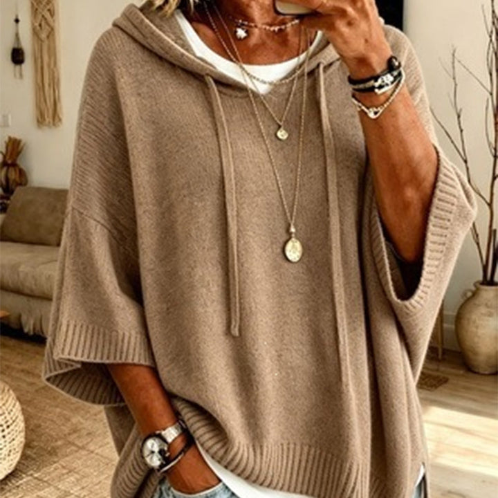 Women's khaki hooded knit sweater detail over a white tee with drawstrings, ribbed cuffs and layered necklaces.