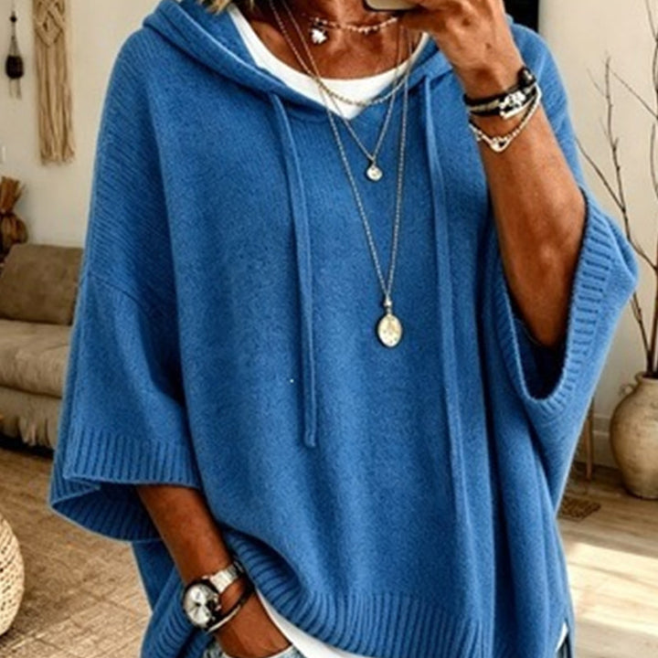 Women's medium blue hooded knit sweater detail with drawstrings, wide ribbed sleeve cuffs and a white tee underneath.