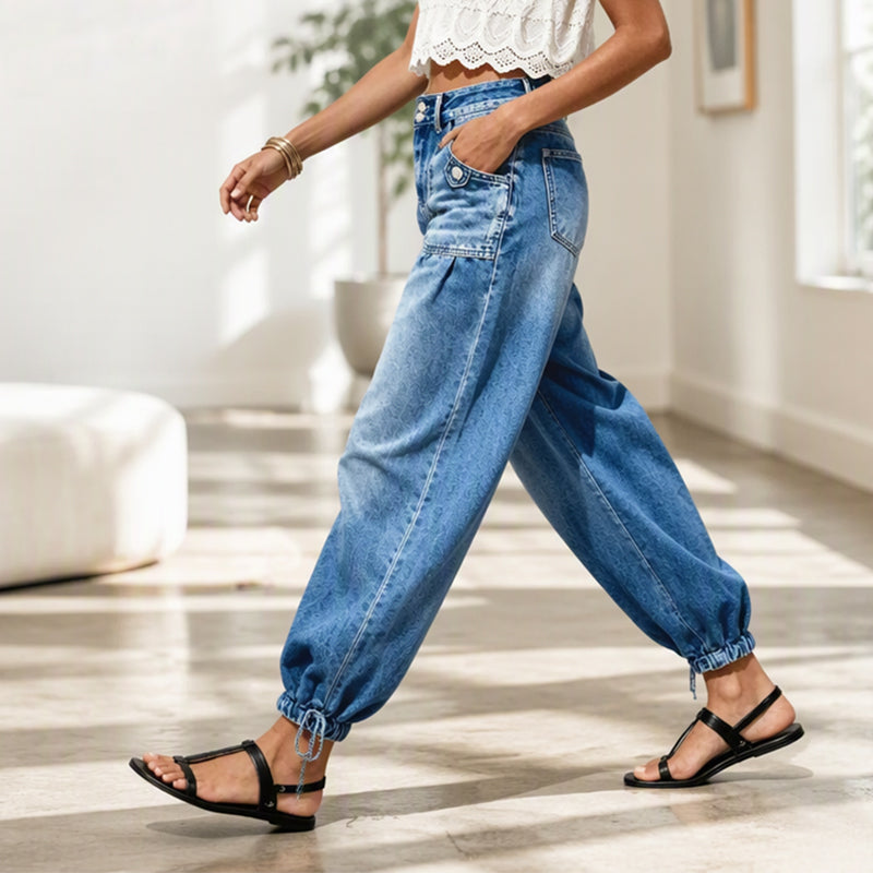 Women's blue barrel jeans side view with rounded leg and gathered tie hems.
