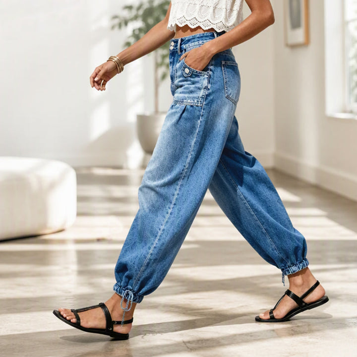 Women's blue barrel jeans side view with rounded leg and gathered tie hems.
