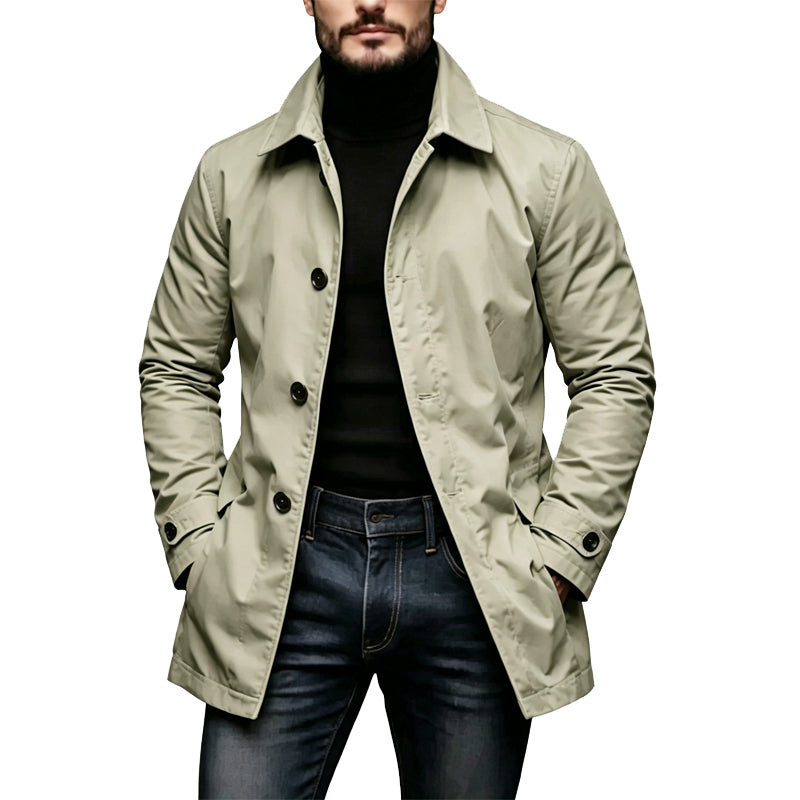 Man wearing the light khaki-beige version of the coat, buttoned at the front, with a black turtleneck and dark jeans. 3