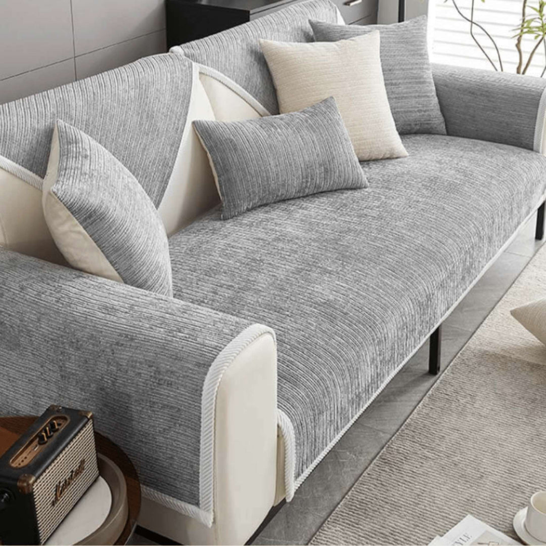 Grey anti-slip protective sofa cover fitted over a sofa with cushions