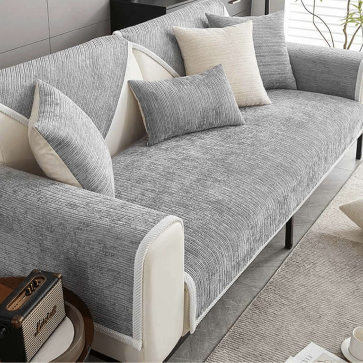 Grey anti-slip protective sofa cover fitted over a sofa with cushions