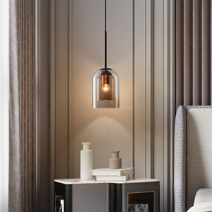 Single smoke glass pendant glowing beside a bed above a marble-topped nightstand with vases and books 3