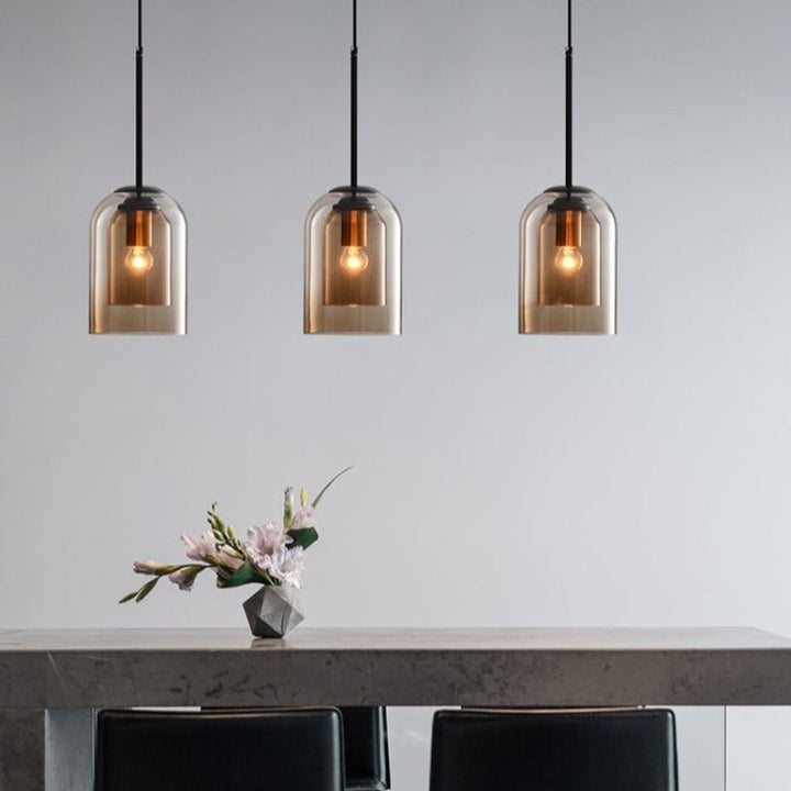Three amber glass pendants hanging in a row over a dining table with flowers 5