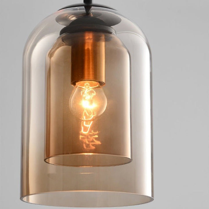 Close-up of the amber double glass shade showing a copper-toned socket and lit bulb 9