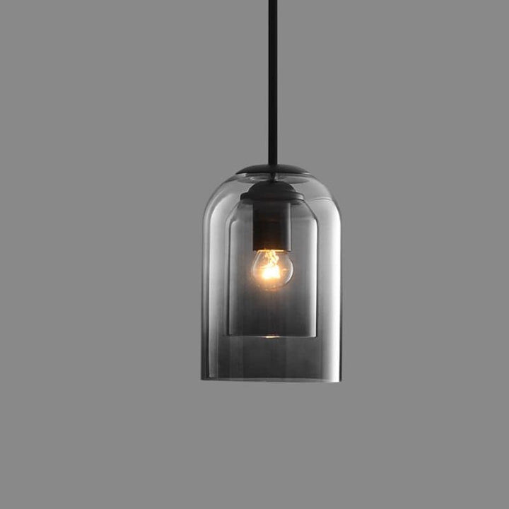 Single smoke gray double-glass pendant with black rod, lit bulb, on a plain gray background 10