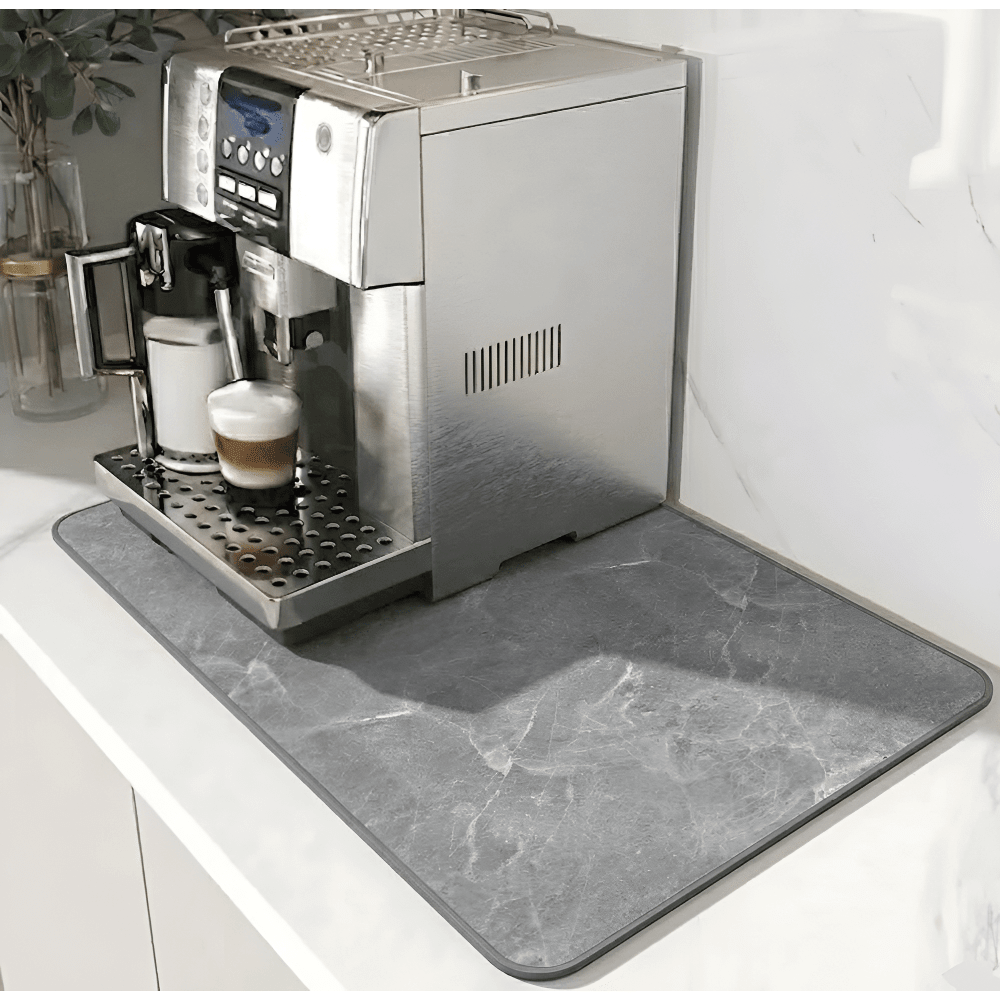 Gray marble-patterned mat with a darker border beneath a silver espresso machine on a white counter 12