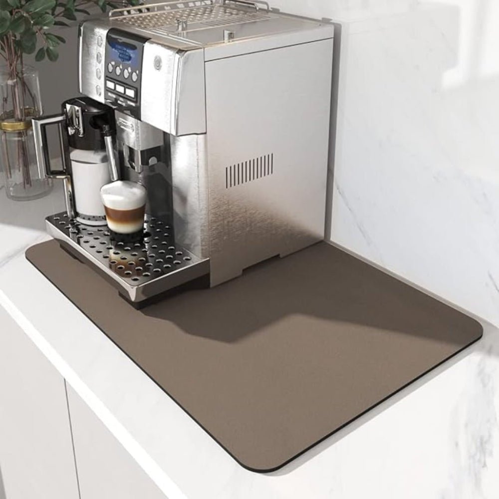 Taupe brown rectangular mat beneath a silver coffee machine on a white marble countertop 3