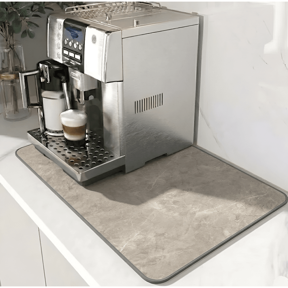 Beige marble-patterned mat with a gray edge under a silver coffee machine on a white counter 11