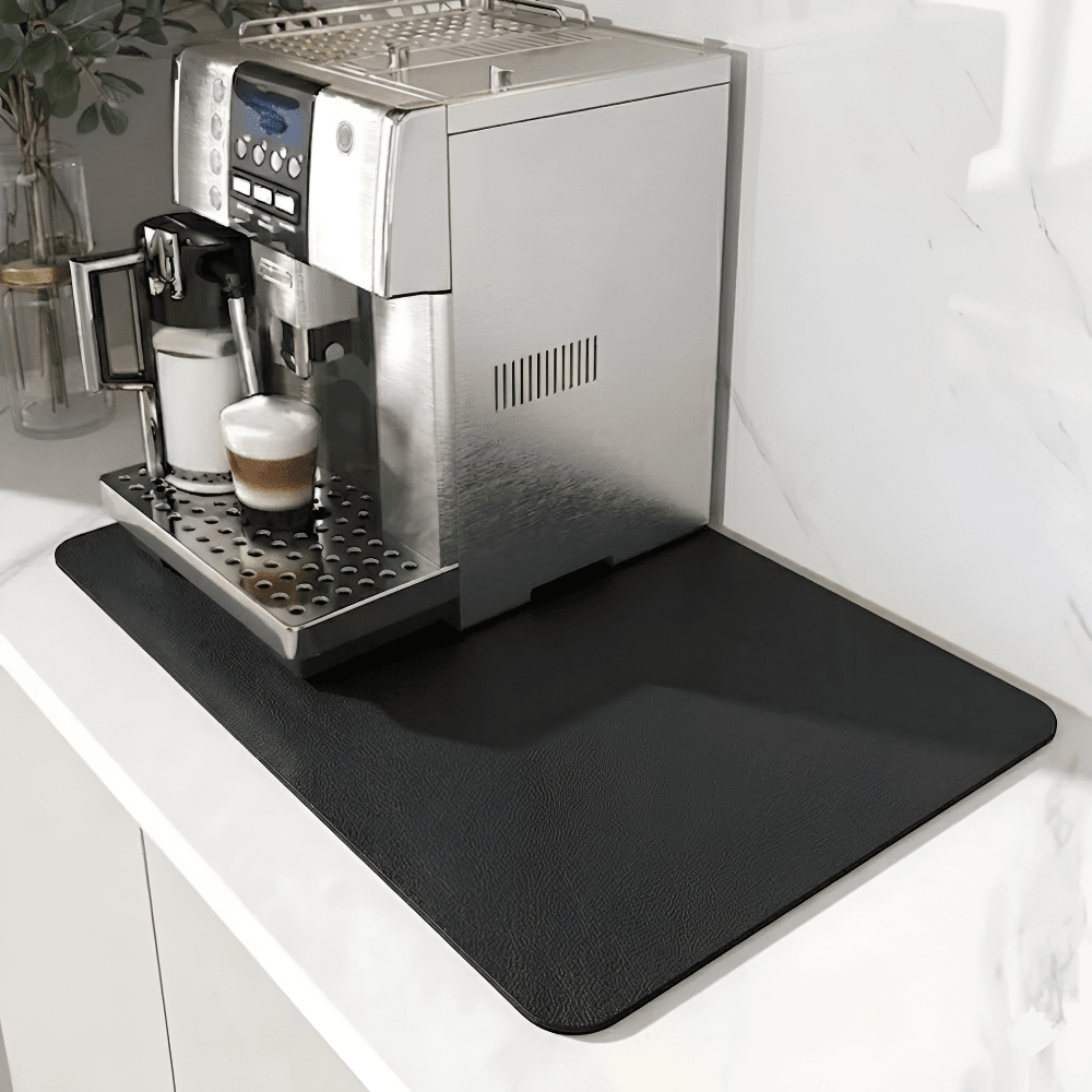 Solid black textured mat under a silver espresso machine on a white marble counter 9