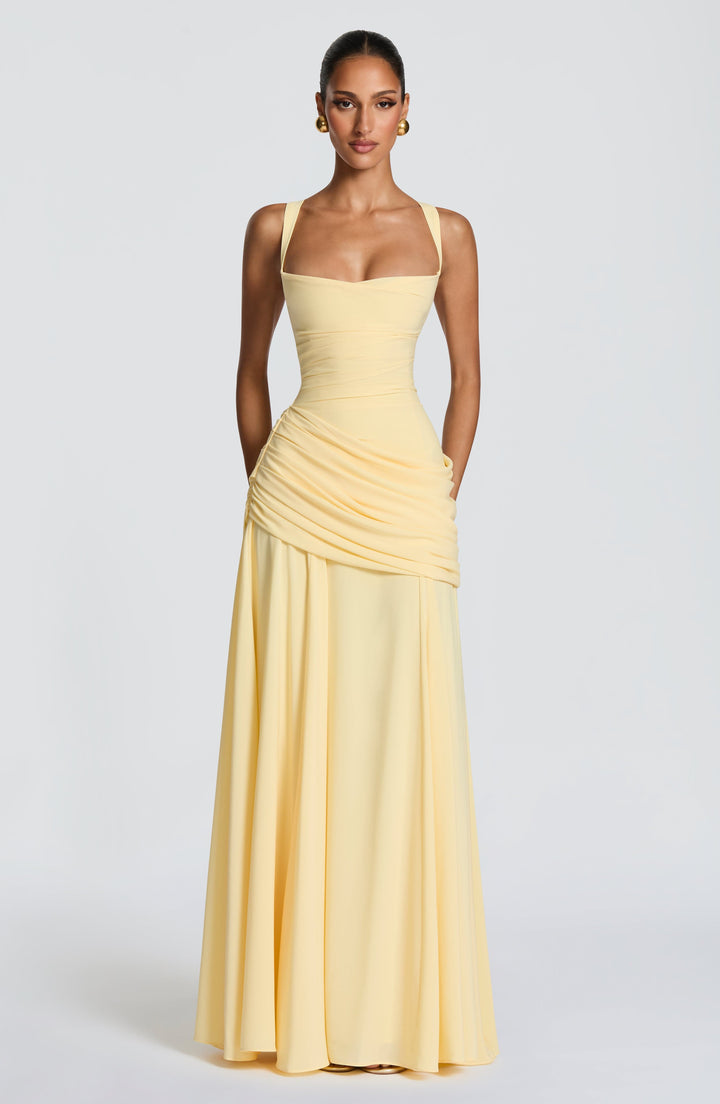 Full-length front view of the pale yellow dress with arms at the sides, showing the long chiffon skirt falling straight.