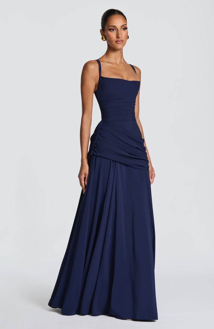 Navy dress from a side angle, showing the gathered ruching at the hip and the long skirt 10