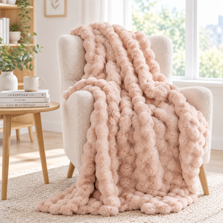 Blush pink plush bubble-textured throw draped over a boucle armchair, spilling onto a woven rug 15