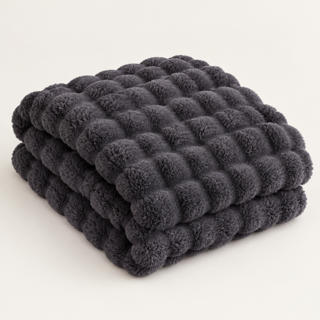 Dark gray bubble-textured plush blanket folded in a neat stack on a plain background 14
