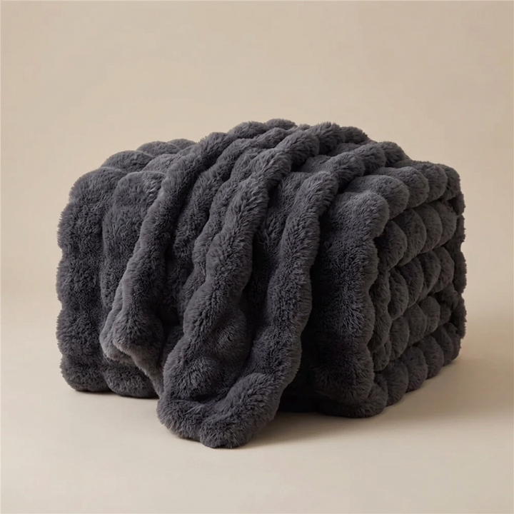 Dark gray plush blanket folded in a stack with the top layer draped over the front 14
