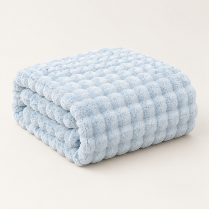 Light blue bubble-textured plush blanket folded in a neat stack on a plain background 12