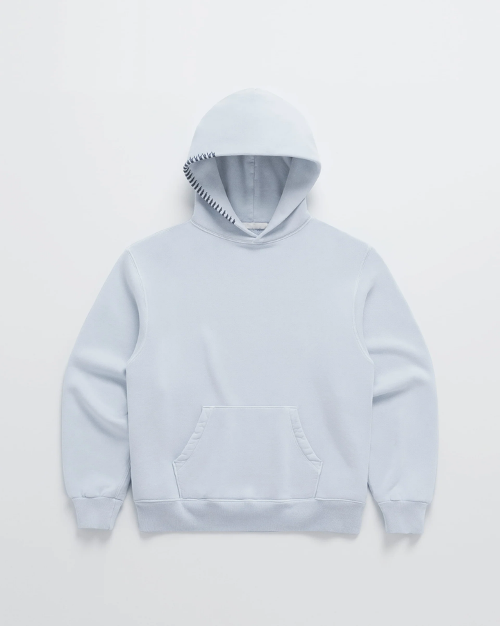 Pale blue hoodie laid flat, front view, with dark navy stitching along the hood edge and a kangaroo pocket 4