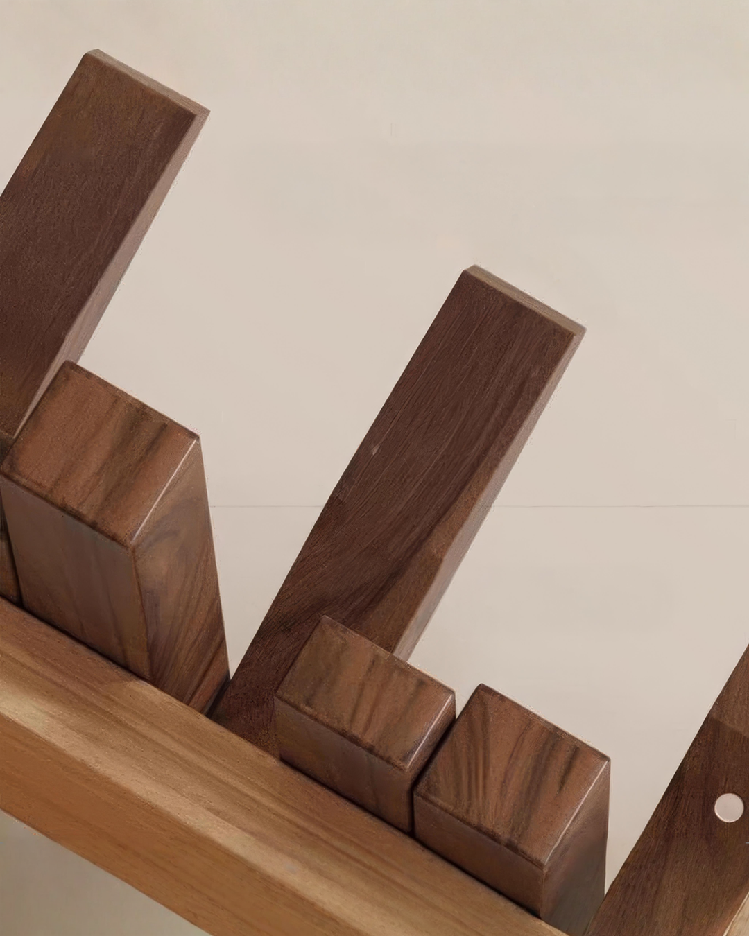 Close-up of the rack's dark wooden bars in different lengths, showing the grain, with the lighter wood mounting strip underneath.