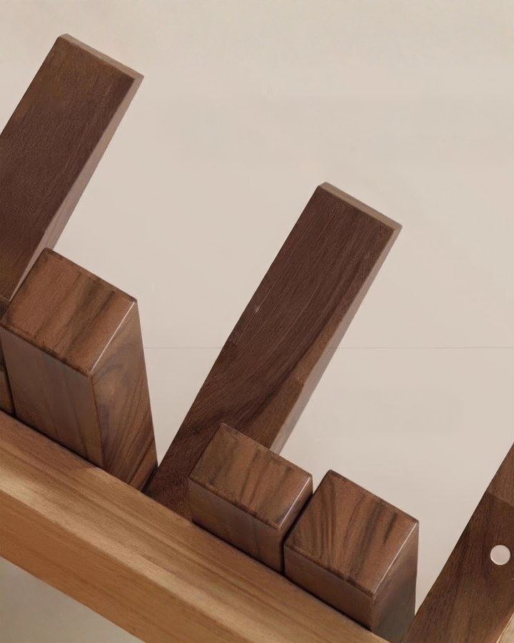 Close-up of the rack's dark wooden bars in different lengths, showing the grain, with the lighter wood mounting strip underneath.