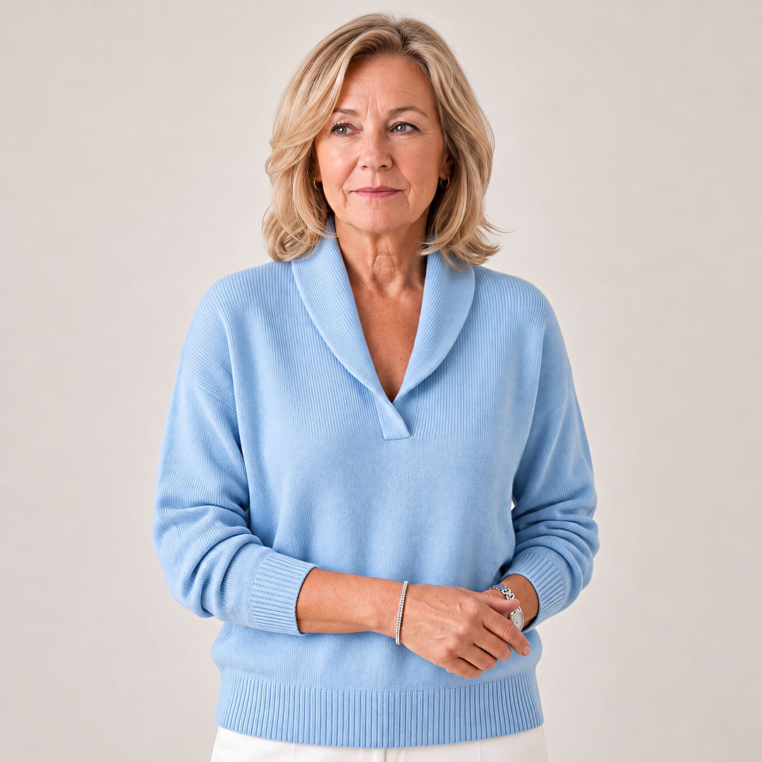 Woman wears the light blue sweater, showing the ribbed cuffs and soft knit.