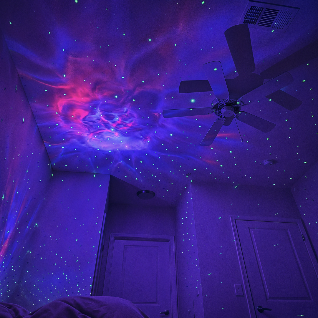 Purple and pink nebula with green stars projected over a bedroom ceiling and walls.
