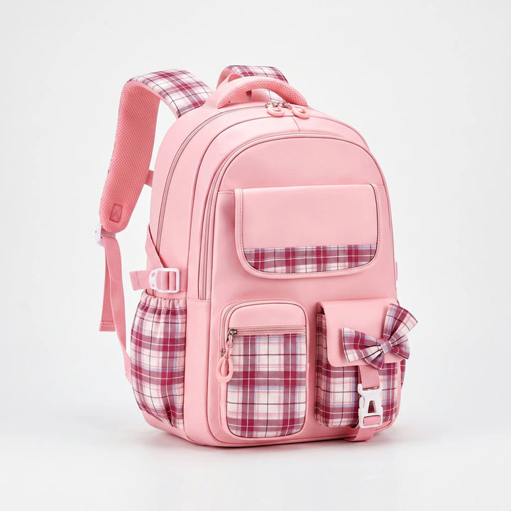 Pink backpack with plaid pockets, side mesh pouch and plaid bow shown at a three-quarter angle.