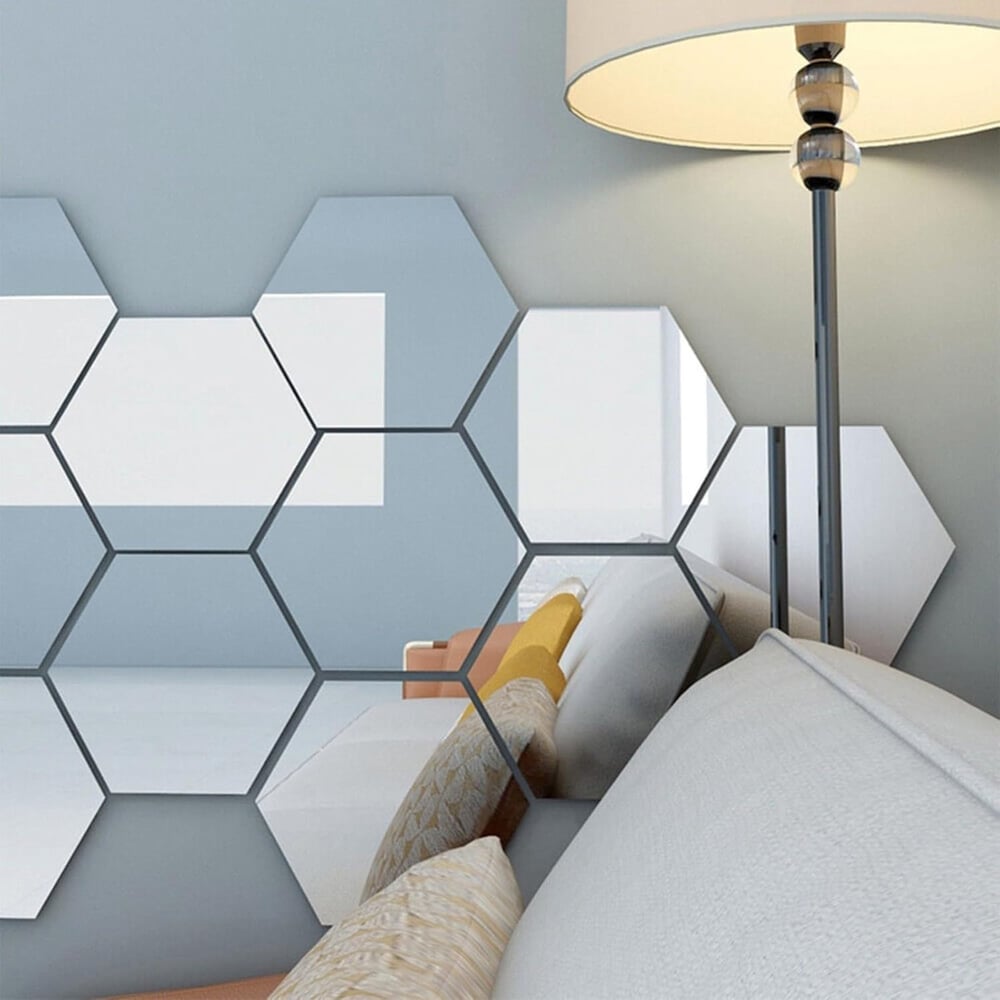 Hexagonal mirror tiles on a pale blue wall beside a floor lamp, reflecting a sofa and cushions 6
