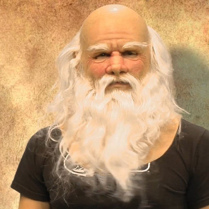 Bald elderly mask with bushy white eyebrows and a long, wavy white beard, worn with a black T-shirt
