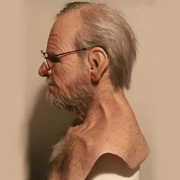 Side profile of a wrinkled elderly man mask with gray hair, gray beard and wire-rim glasses detail