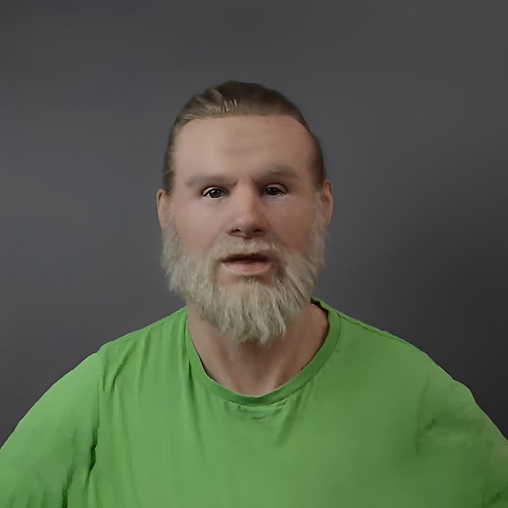 Realistic mask of a man with slicked-back blond hair and a full light beard, worn by a person in a green T-shirt. 29
