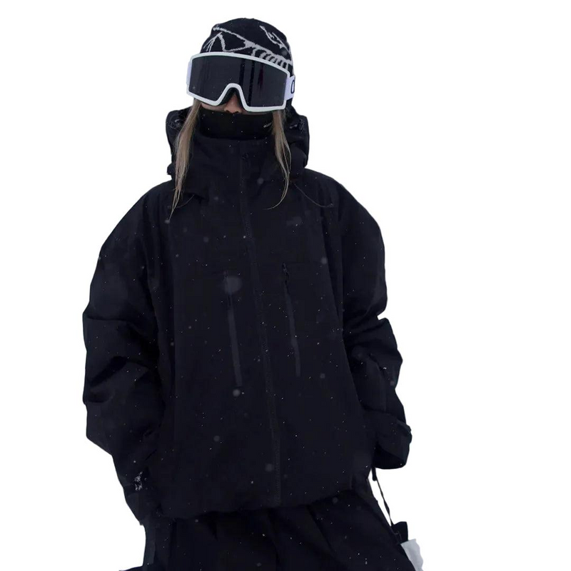 Model in a black jacket with the hood up and ski goggles, front view in falling snow 3
