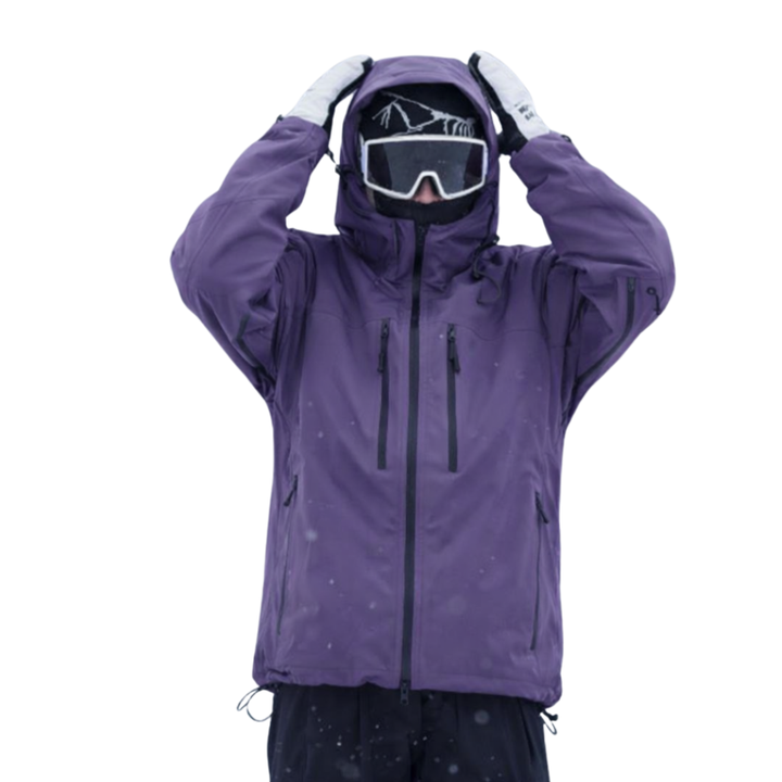 Model in a purple hooded jacket with both hands raised to the hood, front view in snowfall 1