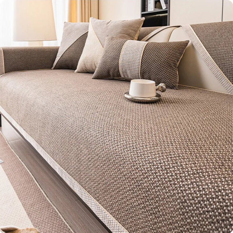 Couch cover in brown woven fabric with a pale braided trim on a sofa, with brown and cream pillows. 10
