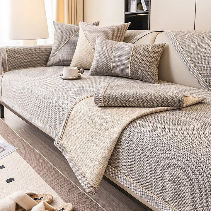 Gray woven cover on a sofa with one corner folded back to show its beige underside and a folded piece on top. 4