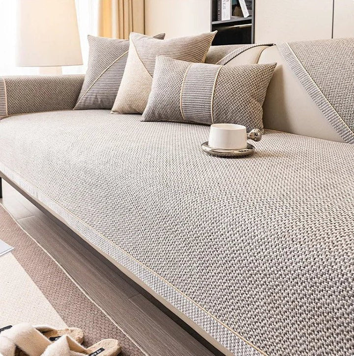 Light gray-beige woven couch cover with braided edging on a sofa, shown with matching pillows and a cup on a tray. 7