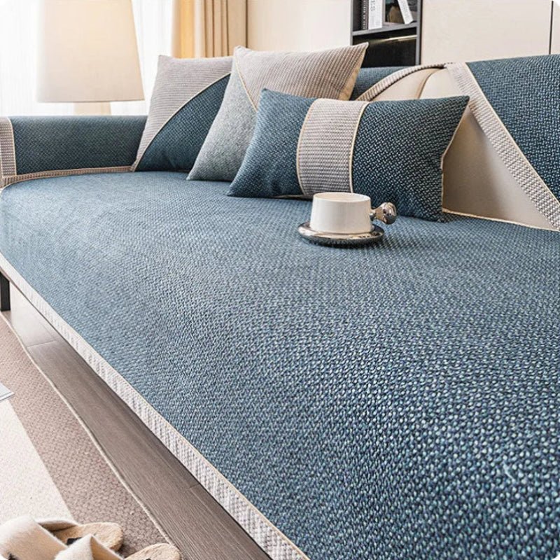 Couch cover in deep teal-blue woven fabric with a pale braided trim on a sofa, with coordinating blue and gray pillows. 8