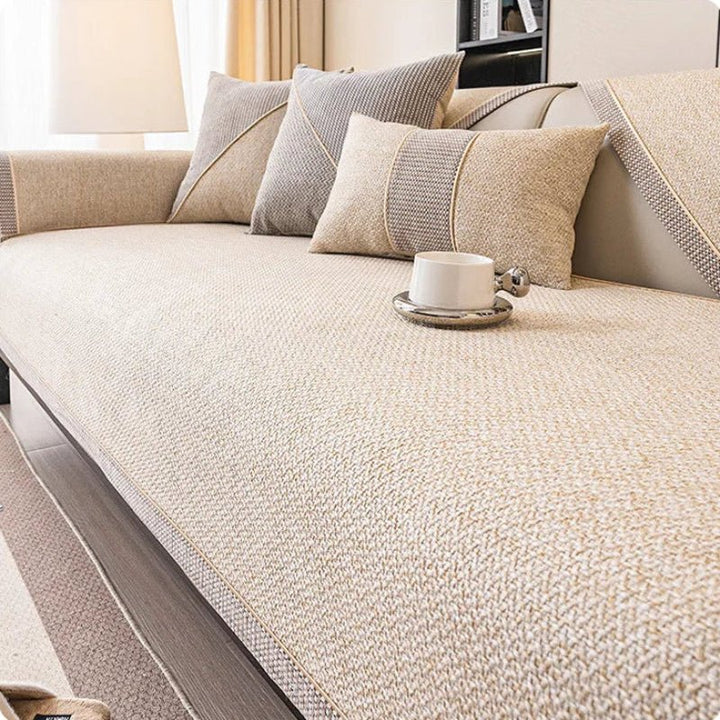 Couch cover in cream beige woven fabric with a braided trim on a sofa, with beige and gray pillows. 9