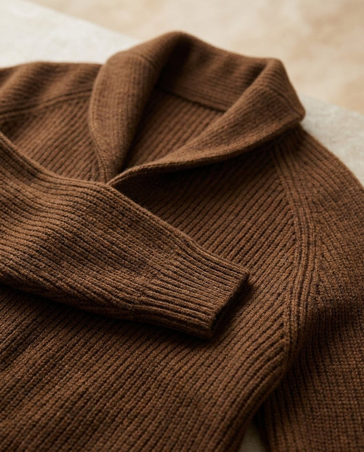 Close-up of the brown cardigan's shawl collar, raglan seam and ribbed cuff, showing the knit texture 13