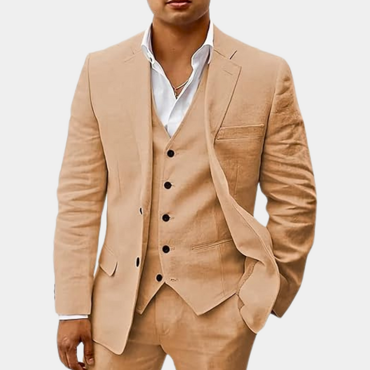 Men's three-piece suit in sandy tan, detail of the jacket open to show the matching vest with black buttons and a white shirt.