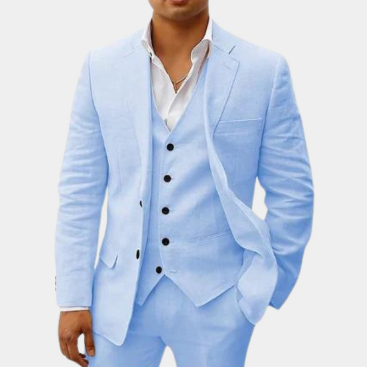 Men's three-piece suit in pale sky blue, detail of the notch-lapel jacket open over a matching vest, white shirt and necklace.