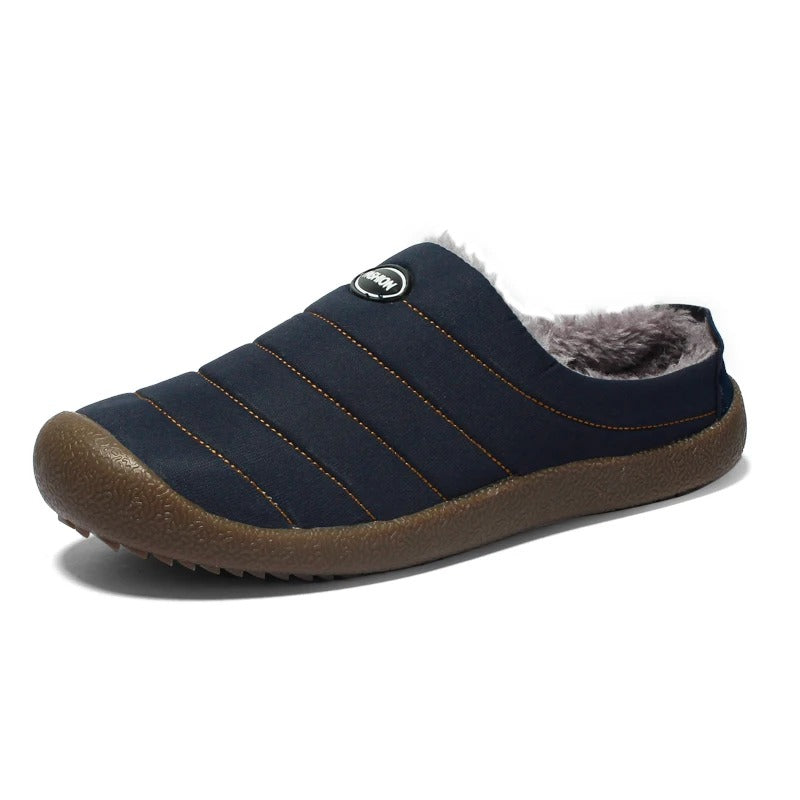 Single navy blue quilted slipper in three-quarter view with orange stitching and brown rubber sole 15