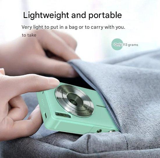 Hand sliding a mint green compact camera into a gray fabric pocket to show how light and portable it is 5