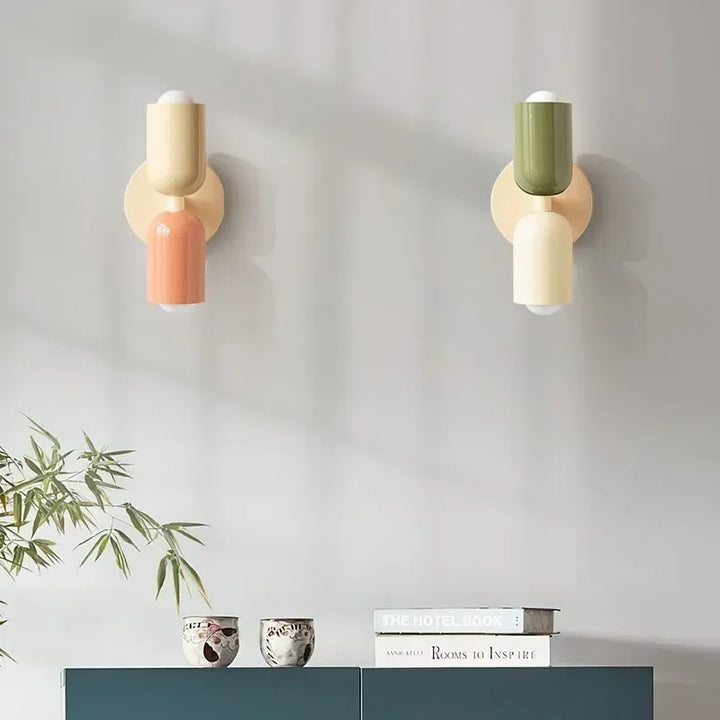 Two retro wall lamps side by side in cream and coral, and green and cream